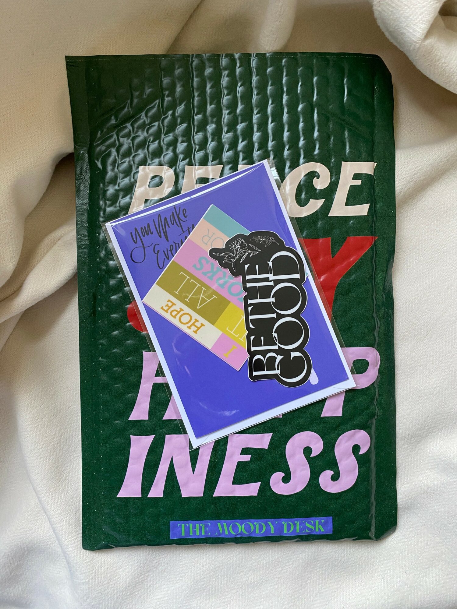 Green book with purple and white text, two cards on top, one with a black dog silhouette, and a yellow and purple design.
