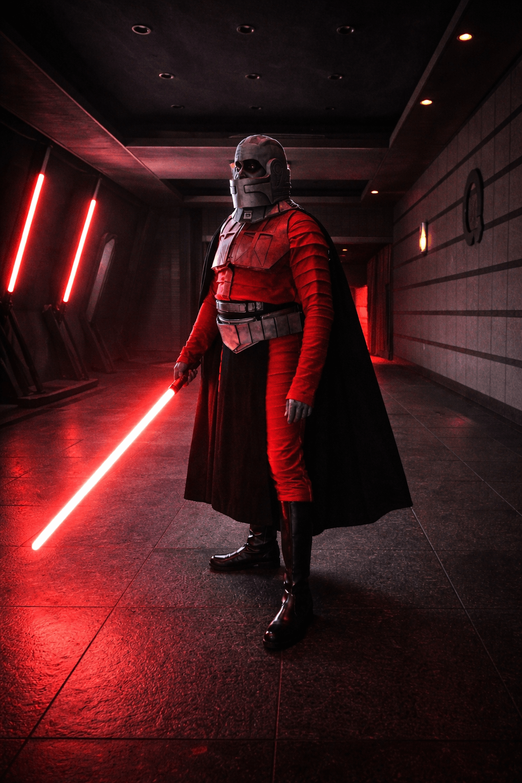 Person dressed as a Star Wars character holding a red lightsaber in a dark corridor with red lighting.