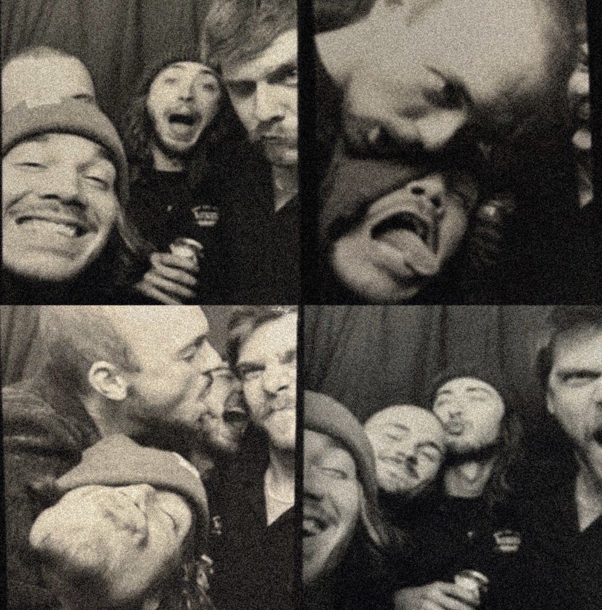 Group of friends smiling and making faces at a party, some holding drinks, in black and white.