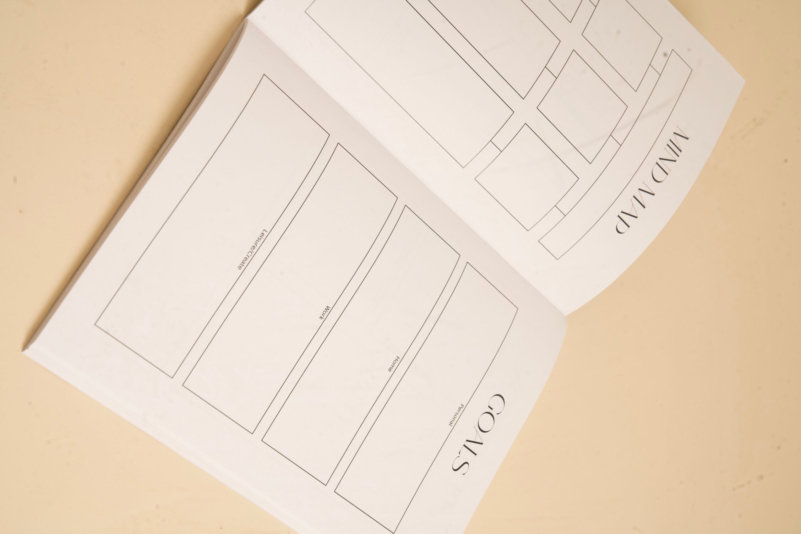 Open booklet with outlined rectangular shapes and small printed labels on its pages.